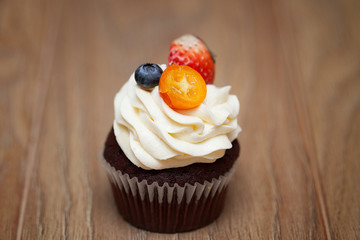 Homemade Chocolate Cupcake with chocolate frosting on wooden table