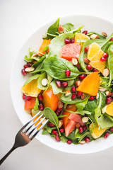 Fresh salad with fruits and greens on white background top view. Healthy food.