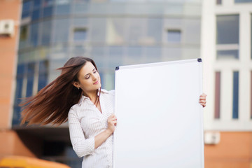 Happy smiling young business woman showing blank signboard