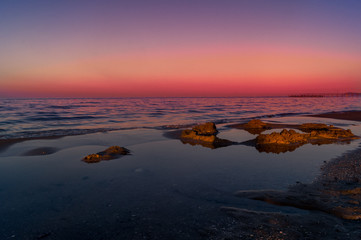 Spiaggia, mare con cielo rosso al tramotno. Sea, beach at sunset with red sky