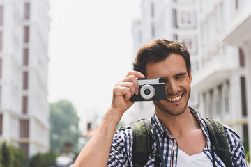 Happy male tourist taking photos of town