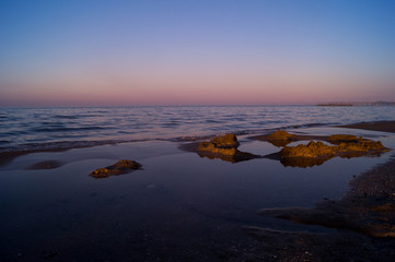 Naklejka premium Mare, spiaggia al tramonto con cielo rosso. Sea, beach at sunset with red sky