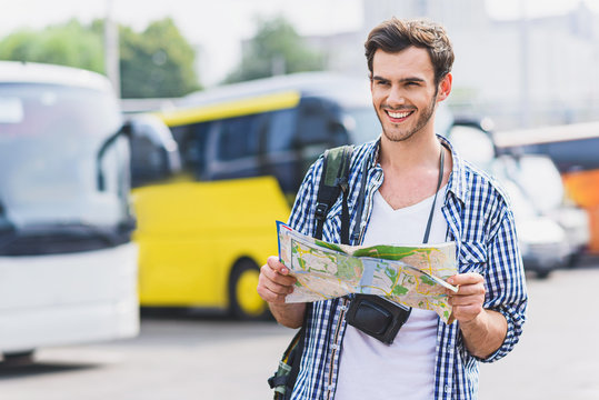 Joyful young man planning his journey