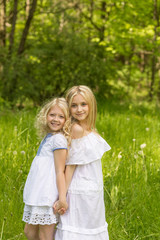 Two young girls relaxing on nature in summer