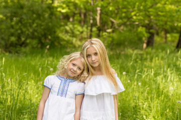 Two young girls relaxing on nature in summer