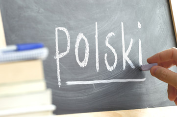 Hand writing on a blackboard in a language class with the word 