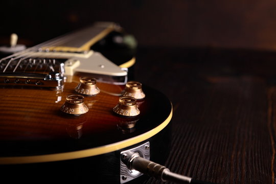 Old electric guitar on wooden table and background