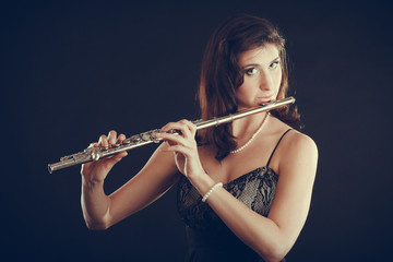Woman playing transverse flute on black. © anetlanda