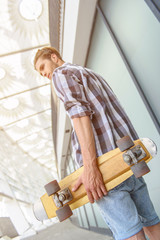 Skillful male skater walking outdoors