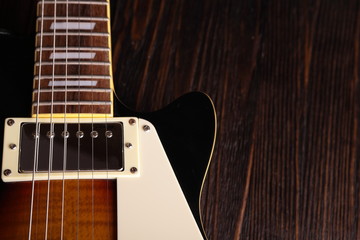 Old electric guitar on wooden table and background