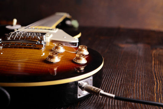 Old electric guitar on wooden table and background