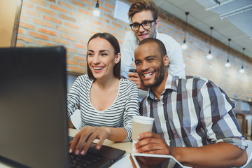 Joyful woman and men relaxing in internet cafe