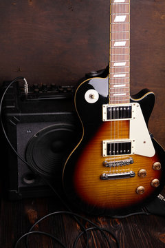 Old electric guitar on wooden table and background