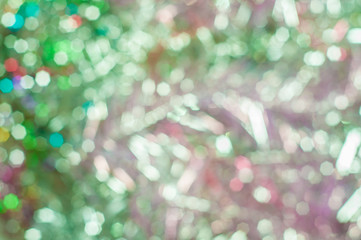 Blurred background with bokeh lights in shades of green and pink