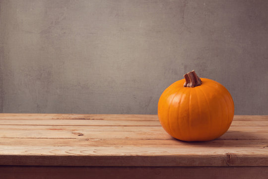 Pumpkin on wooden table over rustic background
