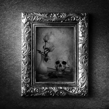 Vintage photo frame, photo of skull with rose over grunge background, Halloween concept, black and white 