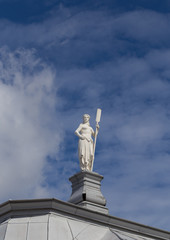Statue in the form of a girl with a paddle, allegory of Navigation, roof Botsogo house in the Peter and Paul fortress, St Petesburg
