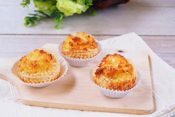Close up of Coconut tarts on a wooden cutting board.