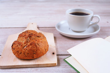 Close of up breakfast with wholegrain bread and coffee on a wooden table.