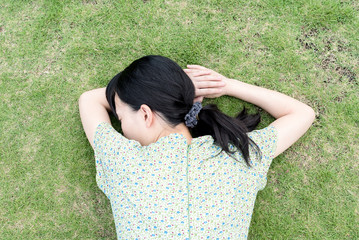 芝生の上で眠る女性