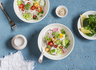 Rice noodles and vegetables salad. Healthy vegetarian food. On a blue background, top view