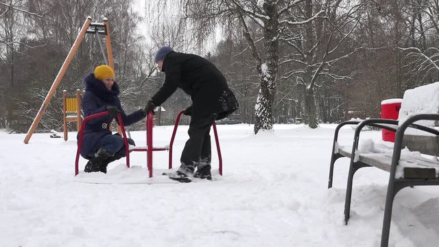man romantic couple spin on colorful circle in outdoor children playground. 4K