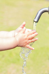 水道で手を洗っている幼児の小さな手