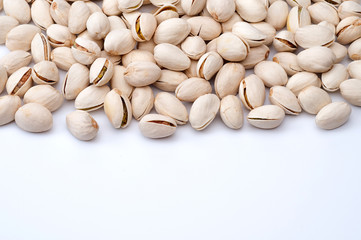 Roasted and salted pistachios in shell on white background