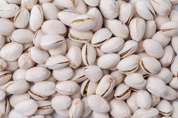 Roasted and salted pistachios in shell on white background