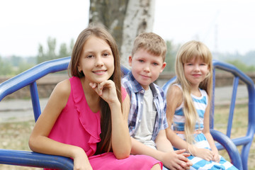 Fototapeta na wymiar Children sitting on bench on the playground