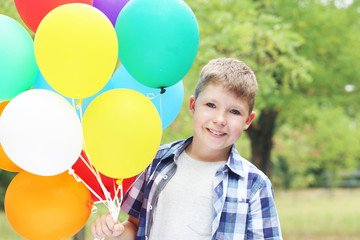 Fototapeta na wymiar Llittle boy with balloons in the park