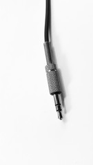 Close up of audio jack with black cable on white background isolated.