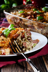 Portion of fusilli pasta casseroles, sausages and zucchini