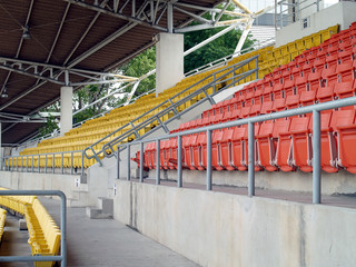 Fototapeta premium row of colourful stadium grandstand seats in sport arena without sport competition