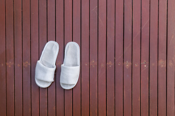 white slipper on brown slat wood