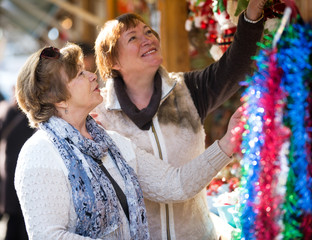 Happy mature women purchasing Christmas decorations