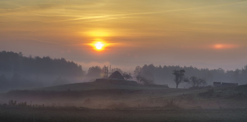 Piękny,mglisty wschód słońca nad wiejską łąką
