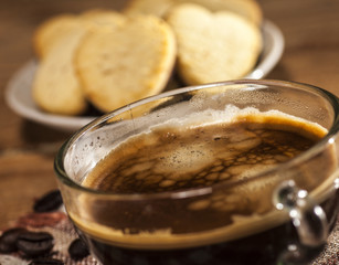 Glass cup with coffee and cookies in a heart shape