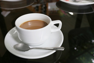 White coffee cup placed on the foods table.