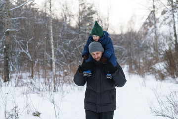 Fototapeta na wymiar Father and child in a winter forest