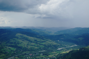 Fototapeta premium Вид с высоты горы природа село тучи туман