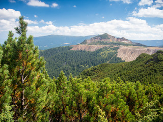 Obraz premium landscape view over a sulfur surface mine near calimani mountains romania