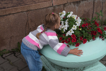 Little girl smelling flowers