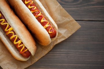 Barbecue Grilled Hot Dog with Yellow Mustard and ketchup on wooden table. Fast food.