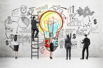 Business team near blackboard with light bulb sketch