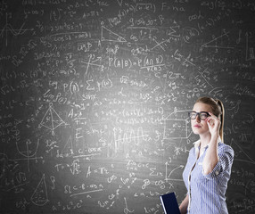 Nerd girl and formulas on blackboard