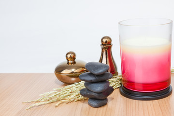 Spa still-life with stacked of stone and burning candles, close-up.