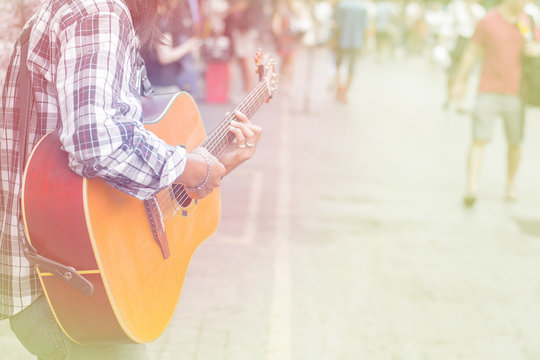 Selective focus man playing guitar on walking street, filter color effect. copy space .Concept music for  life.