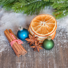 Christbaumkugeln, Orangenscheiben, Zimtstangen und Anissterne auf altem Holz - Weihnachten