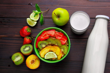 Oatmeals in green plate decorated with slice of strawberry, kiwi